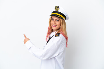 Airplane pilot over isolated white background pointing back