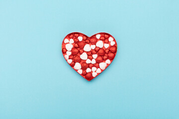 Red white glitter hearts on blue paper background. Happy Valentines Day concept.