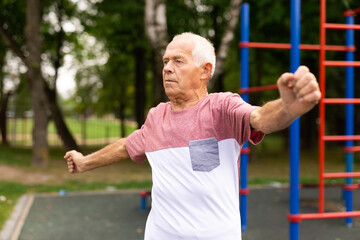 Sports grandfather doing fitness outdoors in park