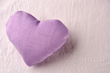 lilac heart on white fabric background