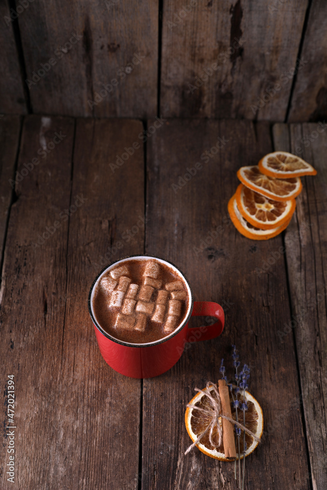 Wall mural drink with marshmallows and cinnamon in a red mug on a wooden background