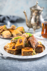 Traditional Turkish Desserts Baklava with  Tea. Crispy mix baklava on silver  plate.