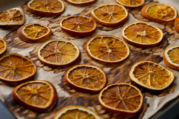 Dried oranges flat lay top view. Background of natural dried oranges on baking paper. The concept of preparing for the holiday, Christmas decorations. Natural toys, eco-design. A sustainable lifestyle