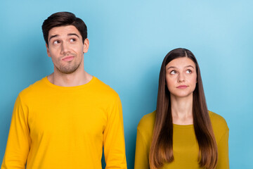 Photo of minded uncertain couple look empty space think wear yellow casual outfit isolated blue...