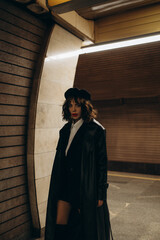 photo session of a girl in the subway in a black coat and beret with red lips