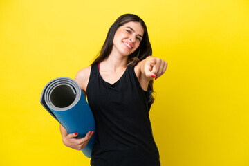 sport Italian woman going to yoga classes isolated on yellow background pointing front with happy expression