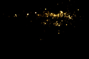 Golden blurred bokeh lights on black background. Glitter sparkle stars for celebrate. Overlay for...