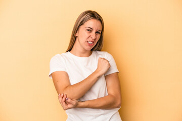 Obraz premium Young caucasian woman isolated on yellow background massaging elbow, suffering after a bad movement.