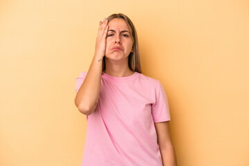 Young caucasian woman isolated on yellow background tired and very sleepy keeping hand on head.