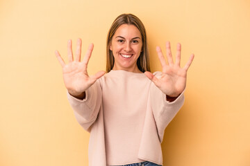 Young caucasian woman isolated on yellow background showing number ten with hands.