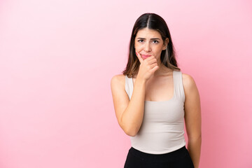 Young Italian woman isolated on pink background having doubts
