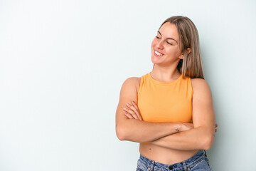 Fototapeta premium Young caucasian woman isolated on blue background smiling confident with crossed arms.