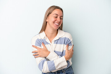 Young caucasian woman isolated on blue background laughing and having fun.