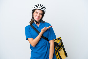 Young delivery woman with thermal backpack isolated on white background presenting an idea while looking smiling towards