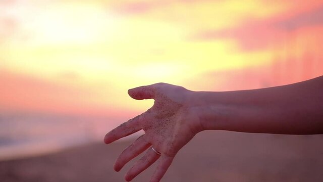 arena desliz&aacute;ndose entre los dedos al atardecer en la playa de Altafulla