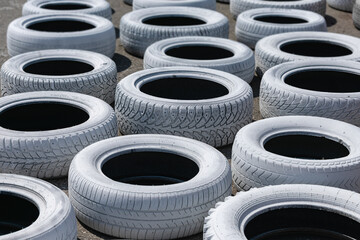 Old used car tires, painted bright white and installed on the race track for safety