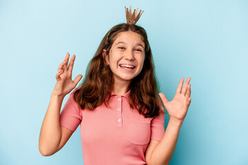 Little caucasian girl wearing a princess crown isolated on blue background receiving a pleasant...