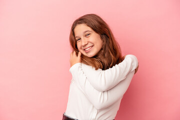 Fototapeta premium Little caucasian girl isolated on pink background hugs, smiling carefree and happy.