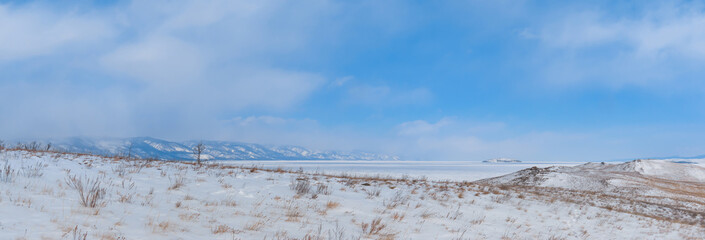 Winter landscape. View of the mountains and frozen Lake Baikal from the Ogoy island. Siberia, Russia