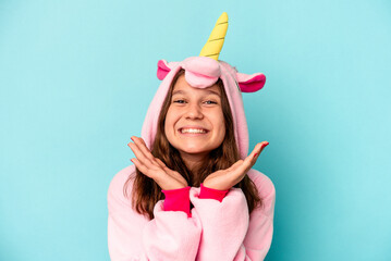 Obraz na płótnie Canvas Little caucasian girl wearing a unicorn pajama isolated on pink background