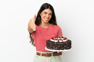 Young caucasian woman holding birthday cake isolated on white background shaking hands for closing a good deal