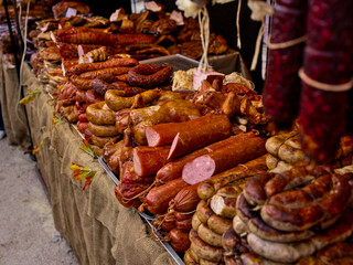 Assorted meat products, including ham and sausages, many semi-finished meat products. Various meat products are offered at a street food fair, event, festival.