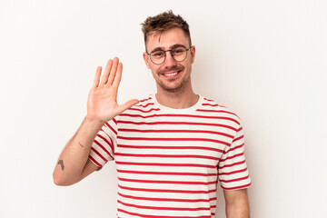 Naklejka premium Young caucasian man isolated on white background smiling cheerful showing number five with fingers.