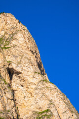 Mountain rock wall at a clear blue sky