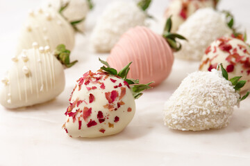 Fototapeta na wymiar White and pink chocolate dipped strawberries on white table