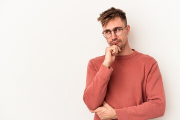 Young caucasian man isolated on white background looking sideways with doubtful and skeptical expression.