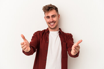 Young caucasian man isolated on white background showing a welcome expression.