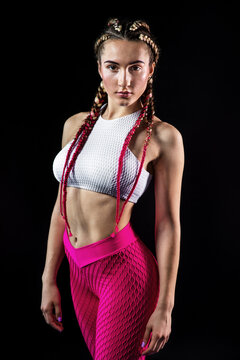 Portrait of sexy young woman in sport outfit looking at camera. Fitness female with muscular body ready for workout on black background