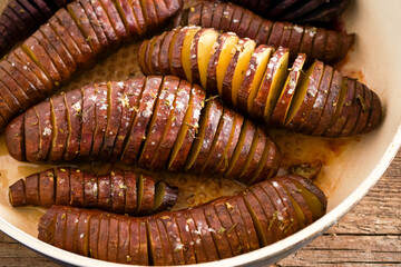 Sweet potato - sweet potatos tubers cooked in a pan. Fried and baked with spices and salt. Cut into pieces and slices. Healthy food close-up top view.