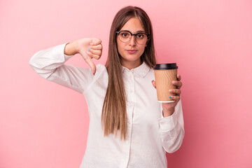 Young business caucasian woman holding a take away isolated on pink background showing a dislike gesture, thumbs down. Disagreement concept.