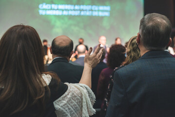Hands in the air of people who praise God at church service - obrazy, fototapety, plakaty