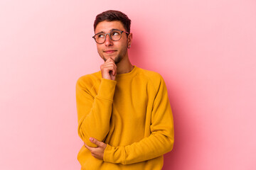 Fototapeta premium Young caucasian man with tattoos isolated on yellow background thinking and looking up, being reflective, contemplating, having a fantasy.