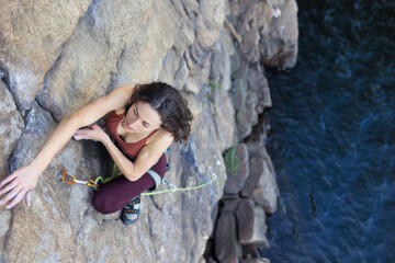 beautiful girl climbs the rock..