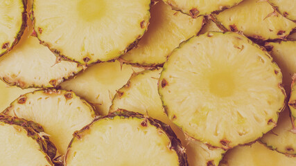 Pineapple juicy yellow slices background. Top view.