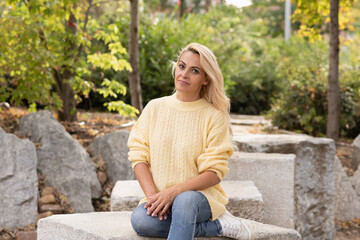Portrait of a blonde woman sitting on a park