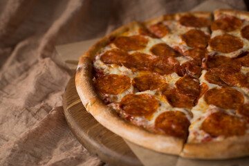 Delicious, aromatic, hot pepperoni pizza on brown background