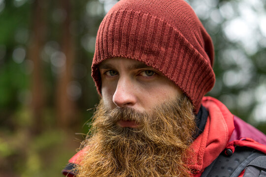 Young hipster man with brown beard wearing knit hat