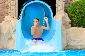 Young teenage boy has fun on the flume in a hotel