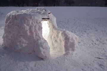 Snow hut for children on the field in the winter evening