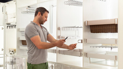 Storage and work spaces organization in kitchen cabinet. The buyer scans the QR code with a...