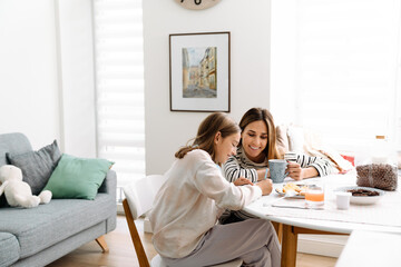 White mother and daughter smiling while having breakfast