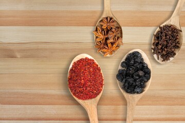Spoons with different legumes on desk background