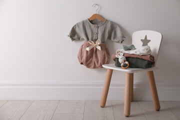 Cute children's clothes and shoes in room. Space for text