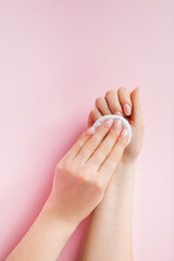 Hand care concept. Young woman remove nail polish on pink background. Place for text.