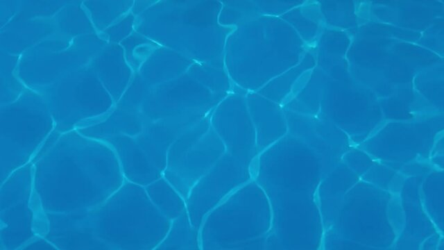 Water drop in swimming pool. Blue color. Ocean lockdown surface. Stop motion video. H2O hotel relax. Sea wave summer texture. Crystal wet waves. Float calm splash. Nobody liquid background