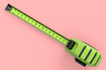 Green carpenter measuring tape isolated on pink with imperial units scale.